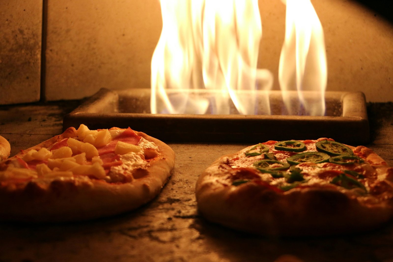 Delicious pizzas with various toppings cooked in a traditional wood-fired oven.